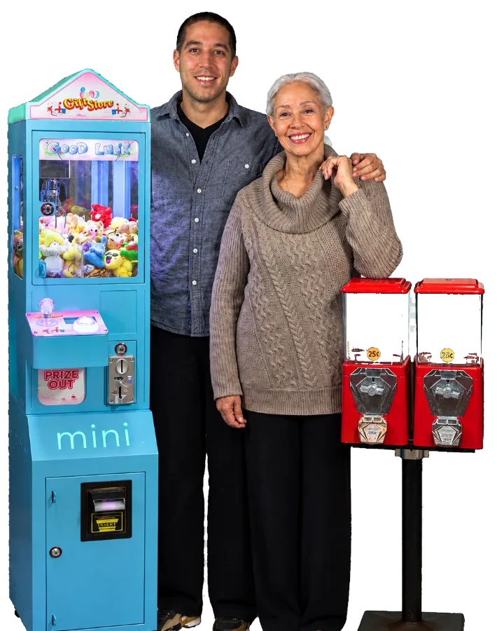 The mother-and-son owners of Hawley Pinball & Amusements standing with a mini crane game and gumball machines